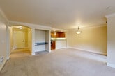Located along Lake Washington Blvd NE in Kirkland, WA, this well-designed 2-bedroom, 2-bathroom residence offers a comfortable and functional single-level layout. The open-concept living, dining, and kitchen area serves as the heart of the home, anchored by elegant crown molding, plush neutral carpeting, and warm interior tones throughout. Arched architectural details add a refined character to the space.

The kitchen is thoughtfully appointed with rich wood cabinetry, granite countertops, stainless steel appliances, hardwood flooring, and a peninsula that provides additional prep and bar seating space. Track lighting illuminates the kitchen, while a pantry adds convenient storage.

The living area features a classic fireplace framed by multiple windows that invite generous natural light and views of lush greenery. Sliding glass doors open to a private balcony, extending the living space outdoors. A dedicated dining area with a pendant light fixture completes the main living zone.

The spacious primary bedroom includes ample closet space and a bright window overlooking the surrounding landscape. The second bedroom is equally well-sized and naturally lit. Both bathrooms are clean and functional, with one featuring a glass-enclosed shower. Multiple closets throughout the unit ensure excellent storage capacity.