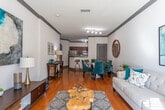 Located on Cheshire Bridge Road NE in Atlanta's vibrant Lindridge-Martin Manor neighborhood, this single-floor residence offers a well-designed layout that balances comfort and functionality. The open living and dining area is anchored by warm hardwood flooring, elegant crown molding with gray accent trim, and a set of French doors that flood the space with natural light. The dining area flows seamlessly into the kitchen through a graceful archway, where rich cherry wood cabinetry, granite countertops, a tile backsplash, and stainless steel appliances create a polished culinary environment. A breakfast bar provides additional seating and connects the kitchen to the main living areas.

The bedrooms are carpeted for comfort, each offering ample closet space, including a mirrored sliding-door closet in one room. Natural light filters through windows dressed with layered curtains, contributing to a calm and restful ambiance. The bathroom features a full tub-shower combination with classic tile surround and granite vanity countertop, maintaining the consistent finish quality found throughout the home.

A dedicated in-unit laundry area houses a full-sized side-by-side washer and dryer, adding everyday convenience. Throughout the residence, thoughtful architectural details—including arched doorways, crown molding, and consistent hardwood flooring—lend a cohesive and refined character to the overall space.