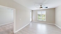 Located at 2420 N Brevard St in Charlotte's vibrant 28205 corridor, this thoughtfully designed one-bedroom residence offers a clean, modern aesthetic across a single floor. The open-concept layout connects the living area and kitchen seamlessly, with light-toned luxury vinyl plank flooring running throughout the main living spaces. The kitchen is a standout feature, showcasing white shaker-style cabinetry extending to the ceiling, stainless steel appliances including a French door refrigerator, electric range, and microwave, along with a large quartz-topped island with an undermount sink and pendant lighting above. A stacked washer and dryer unit is conveniently tucked near the entry. The spacious living area is filled with natural light through oversized windows fitted with white blinds, and is finished with a ceiling fan. The generously sized primary bedroom features plush carpet, a large window with lush greenery views, and direct access to a dedicated closet with built-in shelving. Neutral warm-toned walls throughout lend a cohesive, inviting ambiance, while the overall design balances functionality and contemporary style in a compact, efficient footprint.