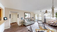 Located at 1088 West Granada Boulevard in Ormond Beach, Florida, this single-floor, one-bedroom, two-bathroom residence offers a well-organized and comfortable layout. The open-concept living and dining area is bright and welcoming, featuring wood-look flooring, a ceiling fan, and large sliding glass doors that flood the space with natural light and provide direct access to a screened patio overlooking a tranquil water view. The kitchen is efficiently designed with warm oak cabinetry, ample counter space, a double-basin sink, and a full suite of appliances, opening conveniently toward the dining and living areas. The primary bedroom is carpeted and includes a ceiling fan and generous closet space, offering a quiet retreat. Two full bathrooms serve the residence, each featuring vanity storage and large mirrors. A dedicated laundry area houses a full-size washer and dryer with built-in shelving above. The screened patio provides a peaceful outdoor sitting area with scenic views of the surrounding landscape. Throughout the residence, an impressive number of closets provide exceptional storage. A separate living room area and a flexible secondary space add to the overall functionality of this well-appointed Ormond Beach home.