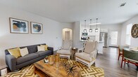 Located in Missouri City, TX, this single-story 2-bedroom, 2-bathroom home offers a thoughtfully designed open-concept layout with wood-look flooring throughout the main living areas. The living room is bright and welcoming, featuring a ceiling fan and connected seamlessly to both the dining and kitchen areas. The kitchen is equipped with stainless steel appliances, including a refrigerator, range, and over-the-range microwave, complemented by white shaker cabinetry, granite-style countertops, a tile backsplash, and a skylight that adds natural light. Pendant lighting over the kitchen island enhances the modern aesthetic. The dining area features a bay window configuration with multiple windows offering outdoor views and ample natural light. The spacious primary bedroom includes plush carpeting, a ceiling fan, a large window, and a generous walk-in closet with built-in shelving. The bathrooms are finished with white cabinetry, clean countertops, and wood-look flooring. A dedicated laundry room accommodates a full-size washer and dryer with overhead shelving for storage. Throughout, the home maintains a neutral, contemporary palette that creates a cohesive and comfortable living environment.