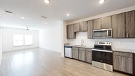 Located at 1050 Old Gilliard Rd in Ridgeville, SC, this single-story, one-bedroom, one-bathroom residence offers a thoughtfully designed layout with modern finishes throughout. The open-concept kitchen and living area form the heart of the home, featuring light wood-look flooring that creates a clean, cohesive aesthetic. The kitchen is well-equipped with warm-toned wood cabinetry reaching toward the ceiling, granite-style countertops, a subway tile backsplash, and a full suite of stainless steel appliances including a refrigerator, electric range, over-the-range microwave, and dishwasher. Natural light filters into the living room through double windows fitted with blinds, while a ceiling fan adds both style and comfort. The bedroom is a comfortably sized retreat with soft carpeting, a ceiling fan with light fixture, a window for natural light, and access to a dedicated closet. The bathroom features wood-look tile flooring, a granite-topped vanity with under-cabinet storage, a large mirror, and safety grab bars. A utility room rounds out the layout, adding functional storage and laundry space. The overall ambiance is clean, bright, and move-in ready.