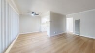 Located at 2633 E La Palma Ave in Anaheim, CA, this one-bedroom, one-bathroom unit offers a well-designed single-floor layout with comfortable, functional living spaces. The open-concept living room and kitchen area is bright and welcoming, featuring light wood-style flooring, crown molding, a textured ceiling, and a ceiling fan with integrated lighting. The kitchen includes white cabinetry, a stainless steel refrigerator, a gas range, and a sink — all efficiently arranged to maximize the space.

The generously sized bedroom is carpeted for comfort and includes mirrored sliding closet doors that enhance the sense of space. A sliding glass door fills the room with natural light and provides direct access to an outdoor patio area. Crown molding and neutral tones carry throughout, creating a cohesive aesthetic.

The bathroom is clean and functional, featuring a tiled shower-tub combination with sliding glass doors, a wood-style floor, a white vanity with a stone-look countertop, and a window that brings in natural light. A hallway connects the main living areas to the bedroom and bathroom, offering a smooth and practical flow throughout the unit. Overall, the space presents a tidy, move-in-ready feel with consistent neutral finishes.