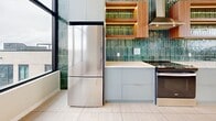 This contemporary office space, located at 2140 Baseline Rd in Ottawa, spans 380 square meters on a single floor. The design embraces an open-concept layout, characterized by its industrial-chic aesthetic with exposed ceiling structures and ductwork painted in a vibrant yellow. Large floor-to-ceiling windows dominate the perimeter, flooding the space with natural light and providing sweeping views of the cityscape.

The office features a variety of work environments, including open collaborative areas, enclosed meeting rooms, and casual seating arrangements. A fully-equipped kitchen boasts modern appliances, sleek cabinetry, and a striking green tiled backsplash. The space incorporates a mix of materials, with concrete columns, wooden accents, and large-format tile flooring creating a harmonious blend of textures.

Thoughtful lighting design is evident throughout, with an array of pendant lights and recessed fixtures illuminating the space. Pops of color in furniture and decor elements add visual interest against the predominantly neutral palette. Amenities include a pool table for recreation and multiple seating areas for informal gatherings or quiet work.

The elevator lobby showcases decorative green tiling, maintaining the design continuity. This versatile office space effectively balances functionality with aesthetic appeal, creating an environment conducive to productivity and creativity.