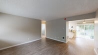 This 730 square foot home in Portland, Oregon offers a thoughtfully designed living space with two bedrooms and one bathroom. The single-story layout maximizes efficiency, with a spacious primary bedroom of 160 square feet. 

The interior boasts modern finishes throughout, including neutral-toned walls and textured ceilings. The living areas feature durable wood-look flooring, while the bedrooms are carpeted for comfort. Large windows in each room provide ample natural light and glimpses of the surrounding area.

The kitchen is a highlight, showcasing granite countertops, white cabinetry, and stainless steel appliances. A convenient pantry with sliding door offers additional storage. The bathroom continues the modern aesthetic with a granite vanity top and a combined tub-shower unit.

Storage solutions are integrated throughout, with sliding closet doors in the bedrooms and built-in shelving in various areas. Baseboard heating ensures comfort year-round. The property's efficient design makes excellent use of its compact footprint, creating a cozy yet functional living environment ideal for individuals or small families seeking a low-maintenance home in the Portland area.