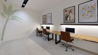 Located in Miami, FL, this thoughtfully designed office space offers a clean, modern working environment within a compact footprint. The room is configured as a shared workspace, featuring a long, natural live-edge wood desk with black metal legs that accommodates multiple workstations, each equipped with a monitor and ergonomic brown leather office chair. Under-shelf LED strip lighting runs along the wall above the desk, providing focused task illumination that complements the recessed track lighting mounted on the ceiling. The walls are bright white, creating a crisp, airy atmosphere, and are adorned with a series of framed botanical and contemporary art prints that add visual interest and warmth. A standout design element is the hand-painted tropical palm tree mural that graces the walls, lending the space a distinctly Miami-inspired character. The floor is finished in large-format light gray porcelain tiles, contributing to the clean, professional aesthetic. A glass-paneled dark-framed door provides entry and allows light to pass through. The overall ambiance is polished yet inviting, blending functional office design with artistic touches that reflect the vibrant cultural identity of its Miami location.