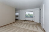 Located at 640 E Armour Blvd in Kansas City, Missouri, this single-floor unit offers a straightforward and functional layout. The living area is finished with neutral-toned carpet and features a large window that invites natural light and frames views of the surrounding greenery. A wall-mounted radiator provides heating, and a ceiling fan is present in an adjacent area, adding to the unit's comfort. The space flows openly, with the kitchen visible from the living area.

The kitchen is efficiently designed, featuring warm oak cabinetry on both sides, offering ample upper and lower storage. It is equipped with a gas range, a refrigerator, and a sink with a window above the counter. The vinyl flooring and flush ceiling light give the kitchen a clean, practical feel.

The bedroom is generously proportioned, with carpeted flooring, a large window that brings in natural light, and access to a dedicated closet. The white walls and neutral tones create a calm, adaptable space.

The bathroom is finished with classic white subway tile wainscoting, a wall-mounted sink, a mirror cabinet, and a toilet, giving it a timeless, clean aesthetic. Overall, this unit presents a functional and well-maintained living space in the heart of Kansas City.