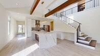Located at 28790 Addison Court in Pepper Pike, Ohio, this contemporary three-floor home offers a thoughtfully designed layout with two bedrooms and five bathrooms across a generous, well-appointed floor plan. The main level makes a striking first impression with its open-concept kitchen and living area, where exposed wood beams contrast beautifully against crisp white ceilings and light-toned hardwood-style flooring. The gourmet kitchen is a standout feature, showcasing sleek white cabinetry, a bold mosaic tile backsplash, stainless steel appliances, and a dramatic waterfall-edge marble island topped with a statement gold ring pendant light. A modern staircase with black metal railings connects the floors, adding an architectural focal point to the main living space. Light-filled hallways lead effortlessly between rooms, benefiting from recessed lighting and abundant natural light. The bedrooms offer plush carpeting, ceiling fans, and large windows with serene outdoor views of the surrounding greenery. The primary bathroom is elegantly finished with large-format tile, a soaking tub, glass-enclosed shower, and a floating vanity with integrated lighting. Additional highlights include walk-in closets, a finished lower level with light wood flooring, and a spacious two-car garage with contemporary panel doors.