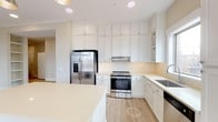 Located at 600 Caraway Crossing in Chapel Hill, NC, this single-floor residence offers a clean, contemporary design throughout. The kitchen is a standout feature, outfitted with crisp white shaker-style cabinetry extending to the ceiling, light quartz countertops, a decorative tile backsplash, and a full suite of stainless steel appliances including a gas range, French door refrigerator, and dishwasher. A large central island provides additional prep space, while a window above the sink fills the room with natural light. The bedrooms are generously sized, finished with plush neutral carpeting and large windows fitted with blinds that bring in ample daylight. The primary bedroom features light hardwood-style flooring, built-in open shelving, crown molding, and a stylish barn-style sliding door leading to an en-suite bath. The primary bathroom is well-appointed with a dual-sink vanity, soaking tub, separate glass-enclosed shower, tile flooring, and direct access to a walk-in closet. A secondary full bathroom mirrors the home's clean aesthetic with a tub-shower combination and tile flooring. A dedicated laundry area accommodates a full-size side-by-side washer and dryer. Throughout, the home maintains a cohesive, light, and airy palette.