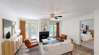 Located at 500 Harbison Blvd in Columbia, SC, this single-floor, 2-bedroom, 2-bathroom residence offers a comfortable and functional layout with thoughtful finishes throughout. The living room serves as the heart of the home, highlighted by a black-surround fireplace flanked by French doors and large windows that flood the space with natural light and provide views of the surrounding greenery. A ceiling fan with integrated lighting adds to the room's comfort and charm.

The kitchen features two-tone gray and white cabinetry, light quartz countertops, stainless steel appliances, and wood-look flooring. A peninsula counter provides additional prep space and casual seating. The kitchen connects seamlessly to the main living area, supporting an open and functional flow.

The primary bedroom offers a carpeted floor, a generous window with garden views, and dedicated closet space. The second bedroom is similarly well-proportioned. Both bathrooms are cleanly finished — one featuring gray vanity cabinetry with quartz counters and wood-look tile flooring, the other accessible via a carpeted hallway with louvered closet doors nearby.

A dedicated laundry room with built-in shelving rounds out the practical amenities. With three closets throughout and a single-floor layout, this residence in the Harbison area of Columbia provides efficient, comfortable living.