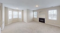 This well-appointed 2-bedroom, 2-bathroom single-story home offers a thoughtfully designed layout that balances comfort and functionality. The living room serves as the heart of the home, featuring plush carpeting, multiple windows that invite natural light, and a classic fireplace with a built-in display niche above — creating a warm and inviting focal point. The kitchen is outfitted with white cabinetry, light granite-style countertops, stainless steel appliances including a refrigerator, range, and microwave, and durable hardwood-style flooring. A door in the kitchen provides convenient exterior access. Both bedrooms are generously sized with soft carpeting and ceiling fans for year-round comfort. The primary bedroom includes access to a walk-in closet. The two bathrooms are clean and functional; one features a dual-sink vanity with a large mirror and modern chrome fixtures, while the second offers hardwood-style flooring and a white vanity. A dedicated laundry room with a full-size washer and dryer adds everyday convenience. Neutral tones and consistent finishes throughout lend the home a cohesive, move-in-ready feel.
