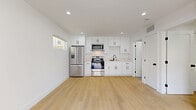 Located on Chestnut Street in Santa Clarita, CA, this efficiently designed single-story unit offers a clean, modern aesthetic throughout. The open-concept layout seamlessly connects the living room, dining area, and kitchen into one bright, cohesive space anchored by warm light wood flooring and crisp white walls. Recessed lighting illuminates the interior, complemented by natural light from well-placed windows.

The kitchen is a standout feature, outfitted with white shaker cabinetry, a subway tile backsplash, light stone countertops, and a full suite of stainless steel appliances including a French door refrigerator, electric range, and over-the-range microwave. Matte black hardware accents add a contemporary touch throughout.

The bedroom is a calm, well-lit retreat with two windows and built-in closet storage featuring open shelving and drawers, maximizing functionality. Two closets provide ample storage.

Both bathrooms are finished in a modern style. One features a tiled tub-shower combo enclosed by a sleek black-framed sliding glass door, complemented by a white vanity with a stone countertop and grey tile flooring. A private patio rounds out the unit, offering outdoor space for relaxation.