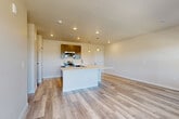 Located in Colorado Springs, CO, this well-designed 2-bedroom, 2-bathroom single-floor home offers a thoughtful layout with contemporary finishes throughout. The open-concept kitchen and living area serves as the heart of the home, featuring a large central island with a white quartz countertop and undermount sink, gray shaker-style cabinetry, stainless steel appliances including a range, microwave, and dishwasher, and light wood-look LVP flooring. Pendant lighting adds a modern touch above the island. The living area is bright and airy, with multiple windows that bring in generous natural light and views of the surrounding neighborhood. Both bedrooms are carpeted and well-sized, each with windows that overlook the outdoors and access to dedicated closets equipped with dual hanging rods and shelving for ample storage. The primary bathroom features a dual-sink vanity with white countertops and gray cabinetry, a tiled shower-tub combination, and LVP flooring. The secondary bathroom mirrors this clean, modern aesthetic with a soaking tub, tiled surround, and coordinating cabinetry. A connecting hallway ties all rooms together efficiently, completing this well-appointed and move-in-ready home.