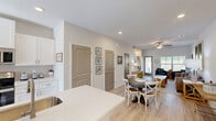 This two-story unit in Augusta, Georgia offers a thoughtfully designed layout spread across two floors. The main level hosts an open-concept kitchen and living area bathed in natural light from large windows and a glass-panel entry door, all complemented by light wood-look flooring and ceiling fans throughout. The kitchen is a standout feature, showcasing crisp white shaker cabinets, a subway tile backsplash, light quartz countertops, a peninsula with an undermount sink, and a full suite of stainless steel appliances including an electric range, built-in microwave, and refrigerator. The living area flows seamlessly from the kitchen, providing a bright and airy atmosphere. A convenient half bathroom is located on the main floor, adding everyday practicality. Upstairs, the generously sized primary bedroom offers a peaceful retreat with natural light from dual windows, a ceiling fan, and dedicated closet space. A full bathroom serves the upper level. The clean, neutral color palette, light flooring, and modern finishes carry consistently throughout the home, creating a cohesive and fresh aesthetic ideal for comfortable everyday living.