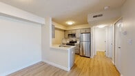 Located at 453 Golfview Blvd in Valparaiso, Indiana, this well-appointed one-bedroom, one-bathroom residence offers a thoughtfully designed single-floor layout. Light wood-style flooring runs throughout, creating a warm and cohesive aesthetic across every room.

The kitchen is a standout feature, equipped with a full suite of stainless steel appliances including a refrigerator, electric range, built-in microwave, and dishwasher. Gray shaker-style cabinetry lines the walls, complemented by clean white countertops. A peninsula with a double sink provides additional workspace and open sight lines into the living area, making the kitchen both practical and connected.

The living room is bright and open, featuring a sliding glass door dressed with vertical blinds that invites natural light and provides outdoor views. The bedroom is a comfortable, well-proportioned space with a natural-light window and a closet for convenient storage.

The bathroom is finished with classic white subway tile in the tub-shower surround, a white undermount sink set into a gray vanity with matching hardware, and the same warm wood-style flooring that flows throughout the home. The overall palette is neutral and clean, offering a move-in-ready feel throughout this efficiently designed residence.