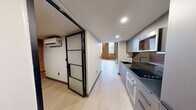 Located at 30 Laurel St in Hartford, CT, this two-story loft space masterfully combines historic industrial character with contemporary design. The main floor features soaring ceilings with striking exposed red steel trusses and warm wood planking overhead, complemented by original exposed brick walls that add texture and depth throughout. Light-toned flooring runs underfoot, and a sleek cable-railing staircase with steel stringers serves as both a functional and architectural centerpiece, leading to the upper level. A dedicated kitchen area is outfitted with flat-front gray cabinetry, dark granite countertops, a matching tile backsplash, an induction cooktop, built-in oven, and stainless steel fixtures — delivering a polished, modern culinary space. The bathroom is clean and contemporary, featuring a multi-function tower shower with tile surround, a modern toilet, dual sinks, and a mirrored medicine cabinet. The upper floor offers an intimate mezzanine-style space framed by large arched and rectangular windows that allow natural light to pour in, with the exposed brick continuing to define the aesthetic. A wall-mounted mini-split system provides climate control throughout. The result is a dynamic, loft-style space that honors its architectural heritage while offering modern comfort and functionality.