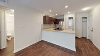 This single-floor residence is thoughtfully designed to maximize functionality and comfort throughout its layout. The open-concept living and dining area is anchored by rich, dark hardwood-style flooring and ceiling fans with integrated lighting, creating a bright and airy atmosphere. Recessed lighting illuminates the space, which flows seamlessly into the kitchen.

The kitchen features a peninsula with a light-toned countertop ideal for casual dining or meal prep. Dark espresso cabinetry provides ample storage, complemented by a mosaic tile backsplash, stainless steel refrigerator, an electric range, dishwasher, and a double-basin sink.

The bedrooms are finished with plush wall-to-wall carpet and feature natural light through blinded windows. Each bedroom is equipped with dual sliding-door closets offering generous storage, and ceiling fans for added comfort.

The bathroom is clean and functional, featuring white subway tile surrounding a full soaking tub with a showerhead, paired with dark cabinetry topped with a light countertop. A laundry area with louvered doors is also accessible from the main living space, adding everyday convenience to this well-appointed home.