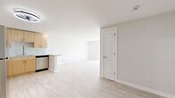 Located at 12155 W 58th Pl in Arvada, Colorado, this thoughtfully designed 2-bedroom, 2-bathroom residence offers a clean, modern aesthetic throughout its single-floor layout. Light wood-style flooring flows seamlessly across the living spaces, creating a bright and cohesive feel.

The open-concept kitchen is a standout feature, outfitted with light natural wood cabinetry, a stone-topped peninsula, glass tile backsplash, and a full suite of stainless steel appliances including a refrigerator, range, microwave, and dishwasher. The adjacent living room is generously sized, bathed in natural light from sliding glass doors fitted with vertical blinds that open to an outdoor area.

The primary bedroom offers comfortable proportions with dual sliding closet doors, a window with natural light, and baseboard heating. The second bedroom is a well-proportioned space with the same light flooring and neutral finishes. Three closets throughout the unit provide ample storage.

Both bathrooms mirror each other in design, featuring large-format white wall tile surrounding a soaking tub with a rain showerhead, white tile flooring, a light wood vanity, and brushed nickel fixtures. The hallway connects all rooms efficiently, completing this well-organized and move-in ready home.