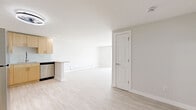 Located at 12155 W 58th Pl in Arvada, Colorado, this thoughtfully designed 2-bedroom, 2-bathroom residence offers a clean, modern aesthetic throughout its single-floor layout. Light wood-style flooring flows seamlessly across the living spaces, creating a bright and cohesive feel.

The open-concept kitchen is a standout feature, outfitted with light natural wood cabinetry, a stone-topped peninsula, glass tile backsplash, and a full suite of stainless steel appliances including a refrigerator, range, microwave, and dishwasher. The adjacent living room is generously sized, bathed in natural light from sliding glass doors fitted with vertical blinds that open to an outdoor area.

The primary bedroom offers comfortable proportions with dual sliding closet doors, a window with natural light, and baseboard heating. The second bedroom is a well-proportioned space with the same light flooring and neutral finishes. Three closets throughout the unit provide ample storage.

Both bathrooms mirror each other in design, featuring large-format white wall tile surrounding a soaking tub with a rain showerhead, white tile flooring, a light wood vanity, and brushed nickel fixtures. The hallway connects all rooms efficiently, completing this well-organized and move-in ready home.