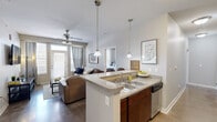 Located in Indianapolis, IN (46202), this single-floor residence offers four bedrooms and four bathrooms within a well-designed, functional layout. The open-concept kitchen and living area serves as the heart of the home, featuring rich dark wood cabinetry, granite-style countertops, stainless steel appliances, and a peninsula with bar seating illuminated by pendant lighting. Polished concrete floors flow through the kitchen and common areas, adding a contemporary industrial touch. The living room is bright and welcoming, benefiting from natural light through large windows and a glass door, and is equipped with a ceiling fan for year-round comfort. Each of the four bedrooms offers a cozy, carpeted retreat with ample closet space and access to natural light. The primary bedroom is an efficiently designed private space suited for comfortable daily living. Each of the four bathrooms is finished consistently with dark wood vanities, large mirrors, and neutral-toned countertops, with some bathrooms featuring walk-in showers. A dedicated entryway area with built-in shelving and bench seating provides practical organization upon entry. The cohesive neutral color palette throughout creates a calm, modern ambiance well-suited to both individual and shared living arrangements.