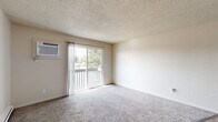 Located at 530 N Edison St in Kennewick, Washington, this two-bedroom, one-bathroom residence offers a well-organized single-floor layout designed for comfortable everyday living. The kitchen is a functional highlight, featuring warm honey-toned wood cabinetry with ample storage, dark granite-style countertops, a white electric range, and durable hardwood-style flooring — providing a practical and inviting space for cooking and meal preparation. The living area transitions between hardwood-style and plush carpet flooring, creating distinct zones within the open layout, with baseboard heating ensuring year-round comfort. Both bedrooms are carpeted and offer a calm, neutral aesthetic, each equipped with double sliding-door closets for generous storage. The primary bedroom receives natural light through a window with views of surrounding greenery, while the secondary bedroom overlooks the neighboring exterior. The full bathroom features a clean white tub-shower combination, wood-toned vanity with dark countertops, and wood-style flooring. A dedicated laundry area with a stacked washer and dryer unit adds everyday convenience. Textured ceilings are consistent throughout, lending a classic residential feel to the entire space.