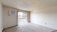 Located at 530 N Edison St in Kennewick, Washington, this two-bedroom, one-bathroom residence offers a well-organized single-floor layout designed for comfortable everyday living. The kitchen is a functional highlight, featuring warm honey-toned wood cabinetry with ample storage, dark granite-style countertops, a white electric range, and durable hardwood-style flooring — providing a practical and inviting space for cooking and meal preparation. The living area transitions between hardwood-style and plush carpet flooring, creating distinct zones within the open layout, with baseboard heating ensuring year-round comfort. Both bedrooms are carpeted and offer a calm, neutral aesthetic, each equipped with double sliding-door closets for generous storage. The primary bedroom receives natural light through a window with views of surrounding greenery, while the secondary bedroom overlooks the neighboring exterior. The full bathroom features a clean white tub-shower combination, wood-toned vanity with dark countertops, and wood-style flooring. A dedicated laundry area with a stacked washer and dryer unit adds everyday convenience. Textured ceilings are consistent throughout, lending a classic residential feel to the entire space.