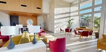 This impressive 2,370 square foot space showcases a harmonious blend of modern architecture and functional design. The single-story layout is characterized by its openness and abundance of natural light, courtesy of floor-to-ceiling windows that offer panoramic views of the surrounding area.

The main area features a spacious lounge with an eclectic mix of seating options, including vibrant pink and yellow armchairs, and a long, neutral-toned sofa. The carefully curated furniture arrangement creates distinct zones within the open space, perfect for various activities or gatherings.

The walls are adorned with large, textured stone tiles, adding a touch of elegance and visual interest. A striking piece of modern art serves as a focal point, introducing splashes of color that complement the furniture.

The kitchen area is sleek and contemporary, boasting ample counter space and high-end appliances. The wood-toned cabinetry contrasts beautifully with the light-colored flooring and walls. A notable feature is the backlit circular mirror, adding a touch of sophistication to the space.

Throughout the interior, recessed lighting and a wood-paneled ceiling create a warm, inviting atmosphere. The seamless flow between indoor and outdoor spaces is emphasized by the glass doors, fostering a connection with the exterior environment.

This versatile space, located at 41766 Grand View Dr, Murrieta, CA, is designed to impress and accommodate various needs, whether for social gatherings, professional events, or everyday living.