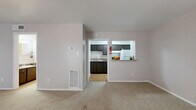 Located at 7500 Clarewood Dr in Houston, TX, this single-floor unit offers a practical and well-organized layout. The open living area features neutral-toned carpet, soft natural light from two front-facing windows, and a ceiling fan, creating a comfortable and airy atmosphere. A centrally positioned entry door anchors the main living space, which flows naturally into the rest of the unit.

The kitchen is efficiently designed with dark espresso cabinetry, granite-style countertops, a tile backsplash, and wood-look flooring. It is equipped with a white refrigerator and an electric range. A pass-through window connects the kitchen to the living area, enhancing the sense of openness. An adjacent pantry provides additional storage, and extra counter space with dark cabinetry extends into a secondary prep area with access to the refrigerator.

The unit includes two bathrooms. The primary bathroom features a dark vanity with a granite-style countertop, a large mirror, and open shelving, with a separate water closet containing a toilet and a full tub-shower combination with white tile surround. Wood-look flooring runs throughout the bathrooms, adding a clean, cohesive finish. A dedicated closet provides ample storage to complete this smartly utilized residential space.