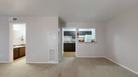 Located at 7500 Clarewood Dr in Houston, TX, this single-floor unit offers a practical and well-organized layout. The open living area features neutral-toned carpet, soft natural light from two front-facing windows, and a ceiling fan, creating a comfortable and airy atmosphere. A centrally positioned entry door anchors the main living space, which flows naturally into the rest of the unit.

The kitchen is efficiently designed with dark espresso cabinetry, granite-style countertops, a tile backsplash, and wood-look flooring. It is equipped with a white refrigerator and an electric range. A pass-through window connects the kitchen to the living area, enhancing the sense of openness. An adjacent pantry provides additional storage, and extra counter space with dark cabinetry extends into a secondary prep area with access to the refrigerator.

The unit includes two bathrooms. The primary bathroom features a dark vanity with a granite-style countertop, a large mirror, and open shelving, with a separate water closet containing a toilet and a full tub-shower combination with white tile surround. Wood-look flooring runs throughout the bathrooms, adding a clean, cohesive finish. A dedicated closet provides ample storage to complete this smartly utilized residential space.