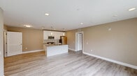 Located at 727 Salem Church Rd in Newark, Delaware, this single-floor, 2-bedroom, 2-bathroom residence offers a clean, modern aesthetic throughout. Light wood-tone flooring runs continuously across the unit, complemented by warm beige walls and crisp white trim, creating a cohesive and welcoming atmosphere.

The open-concept kitchen and living area serves as the heart of the home. The kitchen is equipped with stainless steel appliances, including a gas range, microwave, and refrigerator, set against white cabinetry and granite countertops. A central island with a built-in sink and pendant lighting above provides both additional prep space and a casual dining option.

A central hallway, illuminated by a ceiling fixture, connects the main living area to the private quarters, with multiple closets offering generous storage throughout. The spacious primary bedroom features a ceiling fan, a large window with blinds for natural light, and a double-door closet. The second bedroom is similarly appointed with a ceiling fan and a bright window. Each bedroom is served by its own bathroom — one featuring a tub-shower combination, the other offering a granite-topped vanity with built-in shelving.

The dedicated laundry area houses a stacked washer and dryer unit alongside additional wire shelving, while a separate utility room accommodates mechanical systems.