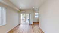 Located at 4383 N Vancouver Ave in Portland, Oregon, this modern three-story home offers four bedrooms and four bathrooms thoughtfully distributed across each level. The open-plan kitchen and living area serves as the heart of the home, featuring light hardwood flooring, dark cabinetry with warm countertops, stainless steel appliances including a dishwasher and range hood, and a large window that fills the space with abundant natural light. The living area extends to a private balcony accessible through sliding glass doors, complemented by a wall-mounted mini-split system for efficient climate control. Each bedroom is bright and well-proportioned, with large windows offering views of the surrounding neighborhood. The primary bedroom provides a comfortable, dedicated retreat. The four bathrooms are finished in clean, modern white with a mix of shower stalls and tub/shower combinations, each equipped with vanities and mirrors. Carpeted stairs with a rich wood handrail connect the three floors, while the consistent use of light hardwood flooring throughout creates a cohesive and airy atmosphere. The home's neutral color palette, recessed lighting, and clean architectural lines contribute to a fresh, contemporary feel throughout.