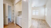 Located on N Hartman Rd in Maricopa, Arizona, this single-story, one-bedroom, one-bathroom residence offers a thoughtfully designed layout with modern finishes throughout. Light wood-style flooring spans the entire unit, creating a bright, cohesive aesthetic that complements the crisp white walls and trim.

The kitchen is a standout feature, showcasing white shaker-style cabinetry, gray quartz countertops, a subway tile backsplash, and a full suite of stainless steel appliances including a range, over-the-range microwave, dishwasher, and refrigerator. A peninsula with pendant lighting above separates the kitchen from the open living area, which features vertical blinds along a full-width sliding door, allowing natural light to fill the space.

The bedroom offers a comfortable footprint, complete with a ceiling fan, a natural light window with blinds, a sliding closet with a hanging rod, and additional built-in shelving for ample storage. A second door in the bedroom provides convenient access to additional spaces.

The bathroom is clean and functional, featuring light wood-style flooring, a glass-enclosed walk-in shower with built-in shelving, a vanity with gray countertops, and a frosted window for natural light and privacy.

A dedicated laundry closet with side-by-side washer and dryer hookups adds practical convenience to the unit. Built-in shelving in the laundry area provides additional storage capacity.