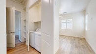 Located on N Hartman Rd in Maricopa, Arizona, this single-story, one-bedroom, one-bathroom residence offers a thoughtfully designed layout with modern finishes throughout. Light wood-style flooring spans the entire unit, creating a bright, cohesive aesthetic that complements the crisp white walls and trim.

The kitchen is a standout feature, showcasing white shaker-style cabinetry, gray quartz countertops, a subway tile backsplash, and a full suite of stainless steel appliances including a range, over-the-range microwave, dishwasher, and refrigerator. A peninsula with pendant lighting above separates the kitchen from the open living area, which features vertical blinds along a full-width sliding door, allowing natural light to fill the space.

The bedroom offers a comfortable footprint, complete with a ceiling fan, a natural light window with blinds, a sliding closet with a hanging rod, and additional built-in shelving for ample storage. A second door in the bedroom provides convenient access to additional spaces.

The bathroom is clean and functional, featuring light wood-style flooring, a glass-enclosed walk-in shower with built-in shelving, a vanity with gray countertops, and a frosted window for natural light and privacy.

A dedicated laundry closet with side-by-side washer and dryer hookups adds practical convenience to the unit. Built-in shelving in the laundry area provides additional storage capacity.