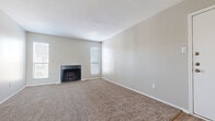 Located at 200 E Brazoswood Drive in Clute, Texas, this single-story home offers a practical and comfortable layout throughout its well-maintained interior. The living room serves as a central gathering space, featuring a classic wood-burning fireplace flanked by two windows dressed with blinds that allow ample natural light to fill the room. Warm, neutral-toned carpet extends throughout the living and bedroom areas, contributing to a cohesive and understated aesthetic. The kitchen is efficiently designed with white cabinetry, white appliances including a refrigerator and range, a double-basin sink, and light wood-look flooring. A peninsula counter separates the kitchen from the adjacent living area, providing additional workspace and an open feel. The entryway transitions seamlessly between wood-look flooring and carpet, offering a welcoming introduction to the home. The bedrooms are generously proportioned, each featuring carpet, ceiling fans, and windows with blinds for natural light and privacy. The bathrooms are clean and functional, equipped with tub-shower combinations, vanities with storage, and wood-look flooring. A dedicated laundry area with overhead cabinetry and in-unit washer accommodates everyday convenience. The home's neutral palette and practical design make it a versatile and move-in-ready space.