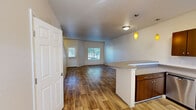 Located at 980 Ross Ave in DuPont, WA, this two-story, 2-bedroom, 2-bathroom home offers a functional and well-designed layout spread across two evenly sized floors. The main level features an open-concept living, dining, and kitchen area with warm wood-style flooring throughout. The kitchen is a standout, equipped with stainless steel appliances including a refrigerator, range, microwave, and dishwasher, complemented by rich dark cabinetry, neutral countertops, and a peninsula with pendant lighting that adds a modern touch. Natural light filters through multiple windows, creating a bright and welcoming atmosphere. A dedicated dining area flows seamlessly from the kitchen into the living space. The upper level houses both bedrooms, each featuring plush carpeting, natural light from windows with blinds, and closet storage. The primary bedroom includes a dedicated closet and access to a full bathroom. A second full bathroom serves the additional bedroom and guests, both finished with wood-style flooring and clean, neutral finishes. Additional highlights include a laundry area, hallway, and ample closet storage throughout. The home's clean, neutral palette and practical layout make it a comfortable and versatile living space.