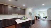 Located at 514 Washington Ave in Dumont, NJ, this single-floor residence presents a thoughtfully designed open-concept layout with contemporary finishes throughout. The kitchen serves as a central highlight, featuring rich dark-espresso cabinetry with brushed nickel hardware, light quartz countertops, a clean tile backsplash, and a full suite of stainless steel appliances including a gas range, microwave, and dishwasher. A central island with bar seating provides additional workspace and casual dining, while warm hardwood flooring extends seamlessly into the adjoining living area.

The living room is generously proportioned, bathed in natural light from a sliding glass door that opens to an outdoor area. Neutral-toned walls and recessed lighting contribute to a bright, welcoming ambiance throughout the common areas.

The bedrooms are carpeted and tranquil, with multiple windows drawing in natural light. The primary bedroom is notably spacious, offering a serene retreat. The primary bathroom features a glass-enclosed shower, a soaking tub, large-format tile flooring, and a dark-cabinetry vanity with a quartz countertop. A well-appointed half bath with a matching vanity style serves the common areas, maintaining a cohesive aesthetic across the entire residence.