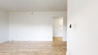 Located at 1011 E Palmer Ave in Glendale, California, this one-bedroom, one-bathroom unit offers a well-organized single-floor layout that makes efficient use of its space. Light wood-style flooring runs consistently throughout, creating a cohesive and clean aesthetic across every room.

The combined kitchen and living area forms the heart of the unit. The kitchen is equipped with white shaker-style cabinetry, a stainless steel refrigerator, and dark countertops, providing a functional and modern cooking space. The adjoining living area benefits from natural light through a window fitted with horizontal blinds, and includes a wall-mounted air conditioning unit for climate control.

The bedroom is a comfortable, well-proportioned room featuring the same wood-style flooring, a ceiling fan with a sleek black fixture, a textured ceiling, and a window that allows in natural light and views of the surrounding neighborhood.

The bathroom maintains the unit's clean, bright aesthetic with white tiled walls surrounding the bathtub and shower combination, wood-style flooring, and a small window that provides natural ventilation and light.

A hallway connects the rooms, contributing to a logical and easy-to-navigate floor plan. Throughout the unit, white walls and consistent flooring create a bright, neutral backdrop well-suited for a variety of furnishing styles.