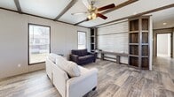 Located at 606 S Park St in Ogden, Kansas, this well-appointed single-floor home offers three bedrooms and three full bathrooms within a thoughtfully designed layout. The living room serves as a welcoming centerpiece, showcasing decorative wood ceiling beams, a ceiling fan with light kit, and wood-look plank flooring. A built-in shelving unit with a shiplap accent wall provides an ideal media area, while multiple windows invite abundant natural light throughout. The kitchen is fully equipped with rich, dark wood cabinetry, marble-look countertops, recessed lighting, a stainless steel range hood, and black appliances including a refrigerator, range, dishwasher, and microwave. A freestanding island with a butcher-block top and built-in storage offers additional prep space and casual seating. The primary bedroom features hardwood-style flooring and connects to a private en-suite bathroom appointed with a dual-sink vanity, marble-look countertops, a soaking tub with a wood-panel surround, and a separate glass-enclosed shower. Secondary bedrooms are carpeted and bathed in natural light. A dedicated laundry room accommodates a full-size washer and dryer. A patio provides outdoor access, completing this functional and stylish home.
