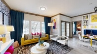 Located at 9111 Lakes at 610 Dr in Houston, TX, this single-story 2-bedroom, 2-bathroom residence offers a thoughtfully designed layout with a bold, eclectic aesthetic. The living room is a standout space, bathed in natural light through large windows dressed with floor-to-ceiling teal drapes. Wood-look flooring, crown molding, and a welcoming entrance set an elevated tone throughout.

The kitchen is outfitted with granite countertops, shaker-style cabinetry with matte black hardware, a grey subway tile backsplash, and stainless steel appliances, including a full-size refrigerator, range, and microwave. An extended counter provides additional prep space.

The primary bedroom features a dramatic statement wall, plush carpeting, natural light from a large window, and access to a spacious walk-in closet with multi-tiered wire shelving. The second bedroom offers a vivid accent wall and ample natural light. Both bathrooms are finished with granite vanity countertops, shaker cabinets, wood-look tile flooring, and a shower-tub combination. A dedicated in-unit laundry area with built-in shelving adds everyday convenience. Three closets throughout the home provide generous storage for residents.