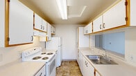 Located at 4505 SW Masters Loop in Beaverton, Oregon, this single-story home offers three bedrooms and three bathrooms within a compact, efficiently designed floor plan. The galley-style kitchen is well-equipped with ample white cabinetry accented by wood trim, a stainless steel sink, electric range, refrigerator, and durable tile flooring. A ceiling fan with light fixture in the adjoining area adds comfort and airflow. Each of the three bedrooms features neutral carpet, light-toned walls, and generously sized windows fitted with vertical blinds that invite natural light and outdoor views of surrounding greenery. The primary bedroom provides a comfortable, private retreat. All three bathrooms maintain a consistent design aesthetic, featuring warm-toned tile flooring, white tub and shower combinations with chrome fixtures, and vanities with ample counter space and cabinet storage beneath well-lit mirrors. A hallway connects the living areas, and a dedicated closet provides additional storage. Baseboard heating units are present in the bedrooms, ensuring year-round comfort. The overall interior presents a clean, neutral palette throughout, offering a functional and move-in ready living environment.