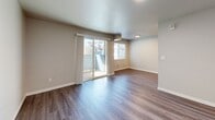 Located at 15110 Macadam Rd S in Tukwila, WA, this one-bedroom, one-bathroom residence offers a well-designed single-floor layout with a clean, modern aesthetic. The open-concept living and kitchen area forms the heart of the home, featuring durable wood-style plank flooring, neutral gray walls, and sliding glass doors that lead to a private balcony, filling the space with natural light and providing outdoor views. The galley-style kitchen is thoughtfully appointed with white shaker cabinetry, brushed nickel hardware, light stone-look countertops, a stainless steel sink, and stainless steel appliances including a refrigerator and electric range. A pantry closet provides additional storage. The spacious bedroom is carpeted for comfort and includes a window for natural light along with a dedicated closet. The bathroom features a white vanity with stone-look countertop, brushed nickel fixtures, wood-style flooring, and a full tub-shower combination. A second closet and a utility panel are also conveniently located within the unit. The consistent use of neutral tones, modern fixtures, and quality finishes throughout creates a cohesive and inviting living environment.