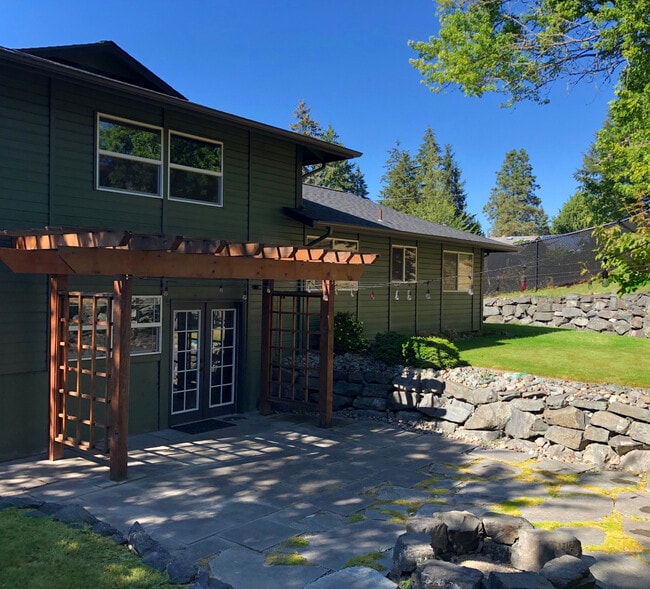 Landscaped backyard with rock walls and stone patio - 8514 41st St W