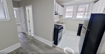 This 650 square foot apartment, located at 305 New Scotland Ave in Albany, NY, offers a thoughtful blend of modern amenities and efficient design. The one-bedroom unit is situated on the third floor (Apt 3C) and comprises a well-appointed kitchen, spacious living area, single bathroom, and a hallway connecting the spaces.

The kitchen showcases crisp white cabinetry, complemented by stainless steel appliances including a gas range and overhead microwave. A window above the sink allows natural light to illuminate the space, while the layout maximizes functionality in the compact area.

The bedroom, measuring 140 square feet, features neutral-toned carpeting and a large window that floods the room with natural light. The living area boasts sleek grey laminate flooring, creating a contemporary aesthetic that flows through to the adjoining spaces. A unique architectural element is the pass-through window connecting the living area to the hallway, enhancing the open feel of the apartment.

The bathroom, while compact, is efficiently designed with a modern vanity, large mirror, and necessary fixtures. The presence of a traditional radiator adds a touch of character to the space.

Throughout the apartment, neutral wall colors and white trim create a bright, airy atmosphere. The abundance of windows in each room ensures ample natural light, making the space feel larger than its actual square footage. The apartment's layout, as seen in the 3D floor plan, demonstrates a clever use of space, offering a comfortable living environment in a urban setting.