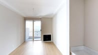 This single-floor space offers a clean and contemporary design characterized by a neutral color palette of soft whites and warm beiges that creates a calm, inviting atmosphere throughout. The main living area features light hardwood flooring that adds warmth underfoot while complementing the minimalist aesthetic of the space. A built-in fireplace serves as a focal point along the wall, providing both a functional heating element and an architectural detail that anchors the room. Large sliding glass doors flood the interior with natural light, opening directly onto a private balcony enclosed by decorative iron railings. The balcony extends the living area outdoors and offers open views of the surrounding environment, making it an ideal spot for relaxation. Crown molding along the ceiling adds a subtle touch of refinement to the otherwise understated design. The open layout promotes a sense of spaciousness and versatility, allowing the room to be arranged in a variety of ways to suit different needs. The overall ambiance is bright, airy, and move-in ready, well-suited for those who appreciate a streamlined, modern living environment.