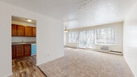 Located at 6340 Stumph Rd in Parma Heights, Ohio, this single-floor unit offers a comfortable and functional layout designed for everyday living. The spacious living room is a standout feature, characterized by expansive floor-to-ceiling windows that frame views of the surrounding wooded landscape, allowing abundant natural light to fill the room. Soft wall-to-wall carpeting, a ceiling fan, and a textured ceiling contribute to the room's relaxed ambiance, while a baseboard heating system and wall-mounted air conditioning unit ensure year-round comfort. The entryway transitions seamlessly between the living area and the rest of the unit, with wood-style flooring extending into the kitchen. The kitchen is well-appointed with warm wood cabinetry, granite-style countertops, a double-basin sink, and white appliances including a range and dishwasher, offering ample storage and workspace. The bedroom is a quiet retreat, featuring plush carpeting, a window with blinds for natural light and privacy, and baseboard heating. The full bathroom is finished with classic white subway tile surrounding a full-size soaking tub and shower, complemented by a vanity with storage and wood-style flooring, creating a clean and timeless aesthetic throughout.