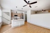 Located at 747 Ralph McGill Blvd NE in Atlanta's vibrant Old Fourth Ward neighborhood, this one-bedroom, one-bathroom residence offers a thoughtfully designed open-concept layout. Light wood-tone flooring runs throughout, complementing the bright white walls and creating a clean, contemporary aesthetic.

The combined kitchen and living area serves as the heart of the home. The kitchen features light natural wood cabinetry, a subway tile backsplash, stainless steel appliances including a French door refrigerator, slide-in range, built-in microwave, and dishwasher. A central island with a white quartz countertop and undermount sink provides both prep space and casual seating. Sleek pendant lighting and a ceiling fan with integrated lighting complete the space. Large windows invite abundant natural light into the kitchen and living area.

The bedroom is a comfortable, well-proportioned retreat outfitted with its own ceiling fan and hardwood-style flooring. Three closets throughout the unit offer generous storage options, supplemented by a dedicated laundry area and utility room.

The bathroom presents a clean, modern design with a wood-vanity base, white quartz countertop, and a tub/shower combination adorned with large-format white tile and matte black fixtures and hardware. A hallway connects all areas of the residence, maintaining a practical and efficient flow throughout.