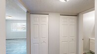 Located at 4323 N Division St in Davenport, Iowa, this two-bedroom, one-bathroom unit offers a practical and efficiently designed single-floor layout. The space features a neutral color palette throughout, creating a clean and cohesive aesthetic.

The kitchen is equipped with white shaker-style cabinetry, a double-basin stainless steel sink, granite-style countertops, and a full-size refrigerator. Wood-look vinyl plank flooring runs through the kitchen, hallway, and secondary bedroom areas, adding warmth and durability.

The primary bedroom is generously sized and features plush carpeting, a textured ceiling, and dual bi-fold closets providing ample storage. A window allows for natural light. The secondary bedroom also offers carpeted flooring, neutral walls, and a window with exterior views of surrounding greenery.

The bathroom includes a vanity with a medicine cabinet mirror, a toilet, and a shower-tub combination with a decorative curtain. Textured walls carry throughout the wet areas.

A connecting hallway links the rooms together in a straightforward, functional layout. Textured ceilings are found throughout the unit. Overall, the space presents a tidy, move-in-ready environment well-suited for those seeking a manageable and low-maintenance home in Davenport.