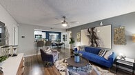 This single-story, 2-bedroom, 2-bathroom residence is thoughtfully laid out to maximize its footprint. The open-concept living, dining, and kitchen area serves as the heart of the home, featuring wood-look flooring, a textured ceiling, and a ceiling fan with integrated lighting. The living room offers generous wall space, while the adjacent dining area is distinguished by a bold navy accent wall. The kitchen is designed in a galley style with white cabinetry, granite-look countertops, a stainless steel sink, and stainless steel appliances, including a refrigerator, electric range, and microwave. A dedicated laundry room with wire shelving is conveniently accessible from the kitchen. Both bathrooms feature white vanities with modern fixtures and wood-look flooring. The primary bedroom includes a walk-in closet with wire shelving systems and carpeted flooring, while a window allows natural light and outdoor views. The second bedroom features a deep navy accent wall and carpeted floors. A hallway connects the bedrooms and bathrooms, and two closets provide ample additional storage throughout the residence.