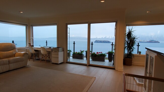 View windows galore in living room with new hardwood floors with in-floor radiant heat throughout! - 1737 Harbor Ave SW Unit S-405