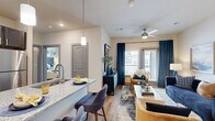 This thoughtfully designed one-bedroom, one-bathroom residence at 5425 E Orem Dr in Houston, TX offers a functional open-concept layout with modern finishes throughout. The living room is bright and inviting, featuring wood-style flooring, a ceiling fan, and large windows dressed with elegant navy drapes that allow generous natural light to filter in. It flows seamlessly into the kitchen, which is a standout feature of the home — showcasing dark shaker-style cabinetry, gleaming granite countertops, stainless steel appliances, and a peninsula with bar seating, ideal for casual dining or entertaining. The bedroom is carpeted for comfort, with multiple windows offering outdoor views, a ceiling fan, and access to a spacious walk-in closet with built-in shelving. The bathroom impresses with dual granite-topped vanities, teal cabinetry, and a wide mirror, connecting conveniently to the bedroom. Additional highlights include three closets for ample storage, a private patio, and an in-unit laundry room equipped with a full-size washer and dryer with overhead shelving. The overall ambiance is modern and cohesive, combining practical amenities with polished design details throughout.